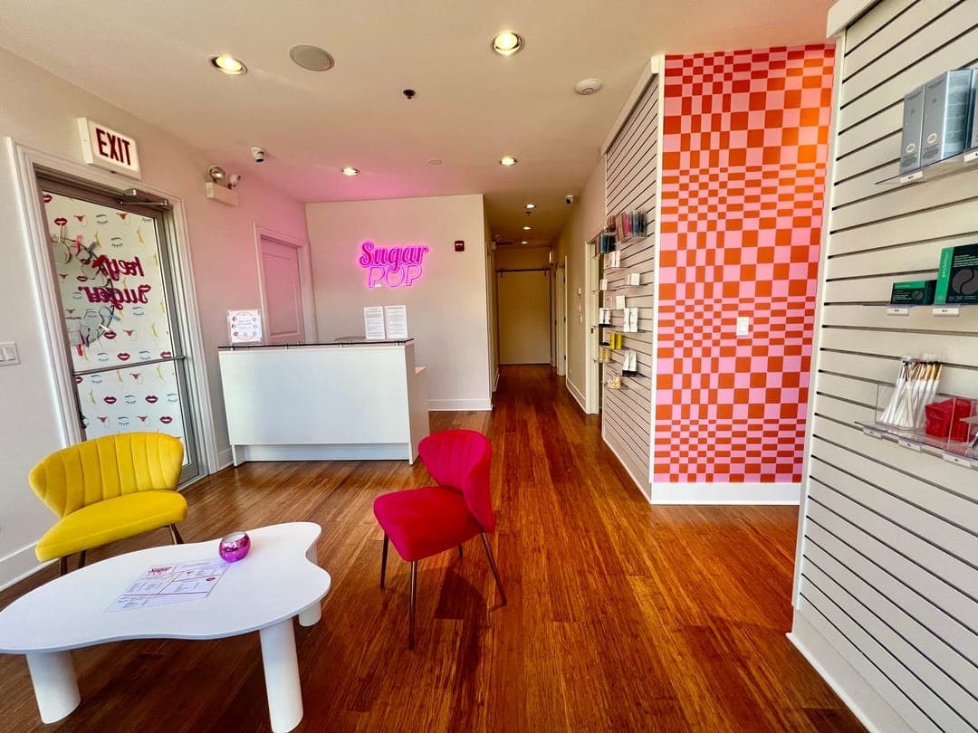 The Sugar Pop Salon lobby, with the pink neon sign and checkerboard wall